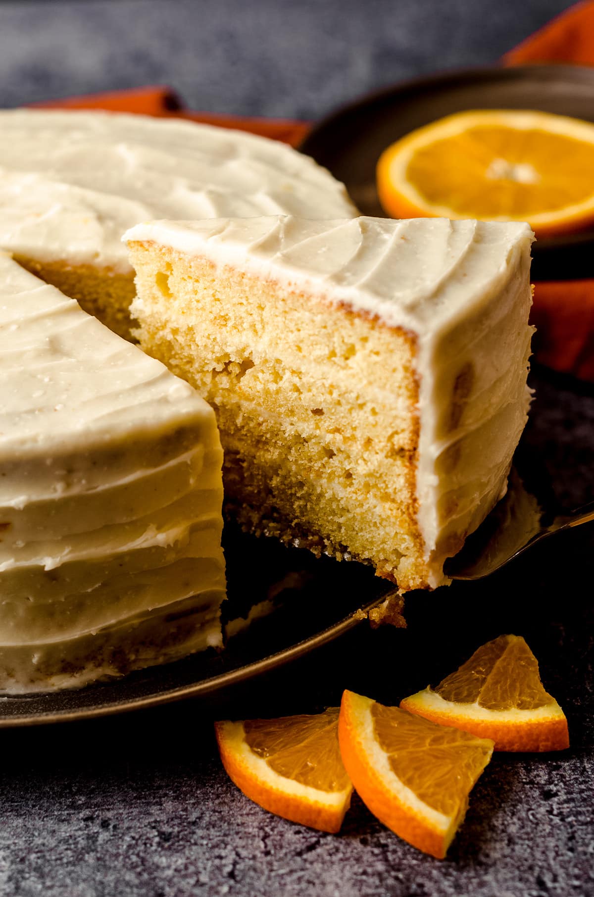 slice of orange creamsicle layer cake being removed to serve