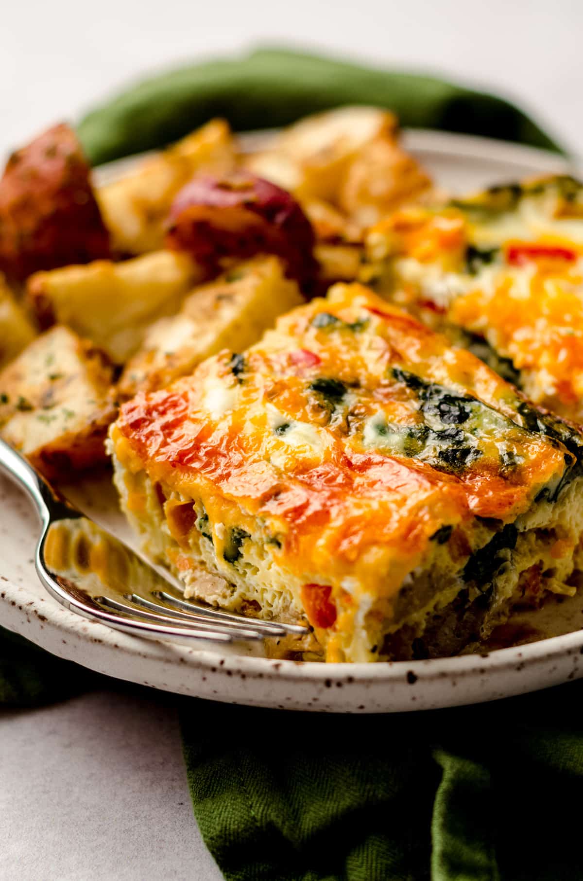 slice of freezer breakfast casserole on a plate with breakfast potatoes