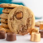 peanut butter rolo cookie sitting in front of a stack of cookies with scattered rolos