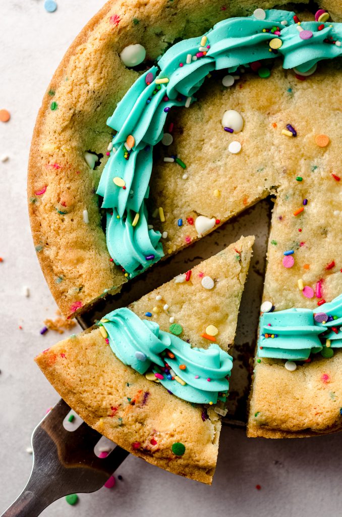 aerial photo of funfetti sugar cookie cake with a slice being taken out of it