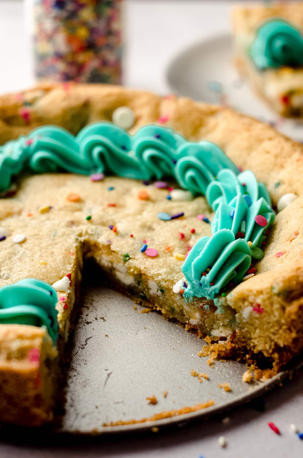 funfetti sugar cookie cake with a slice taken out of it