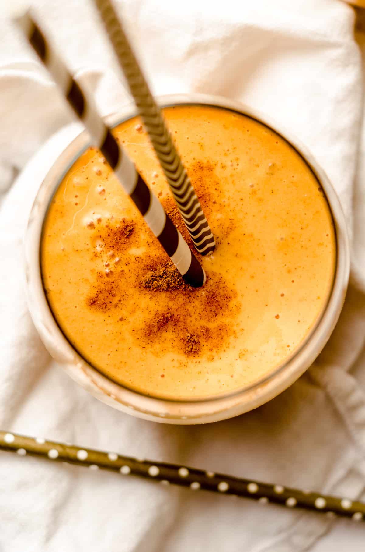 pumpkin pie smoothie in a glass with straws