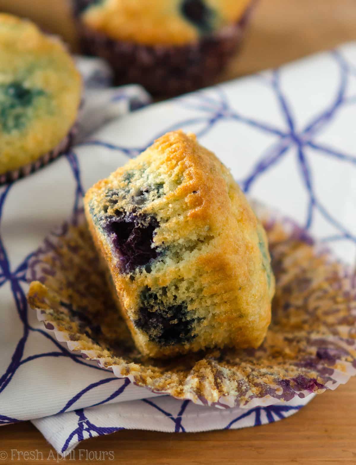 blueberry muffin unwrapped on a white and purple kitchen towel