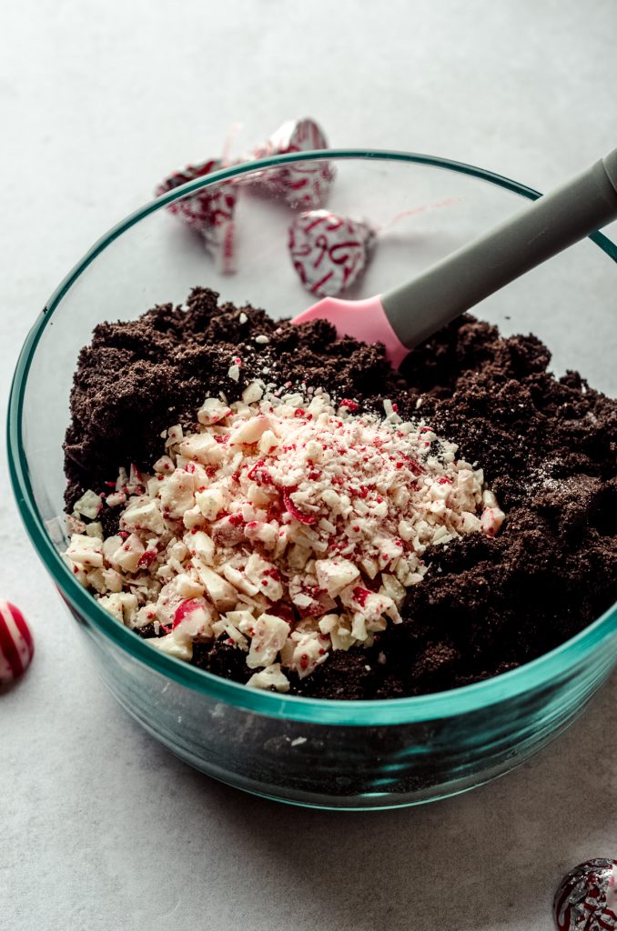 A bowl of crushed Oreos and chopped candy cane Kisses to make a peppermint Oreo crust.
