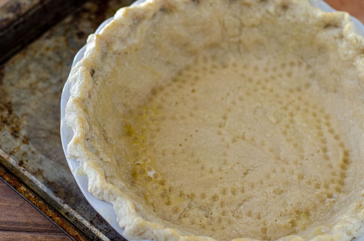 pie crust after blind baking with indentations from pie chain