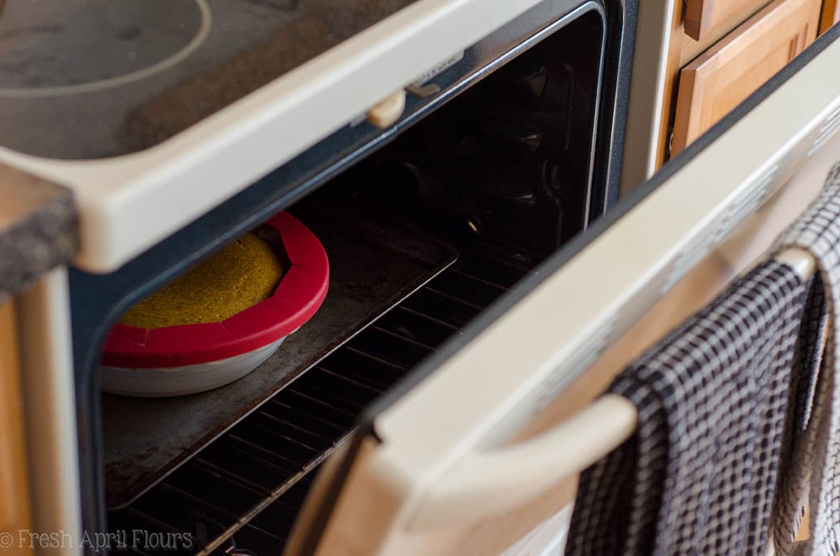 oven door sitting open with a pumpkin pie baking inside