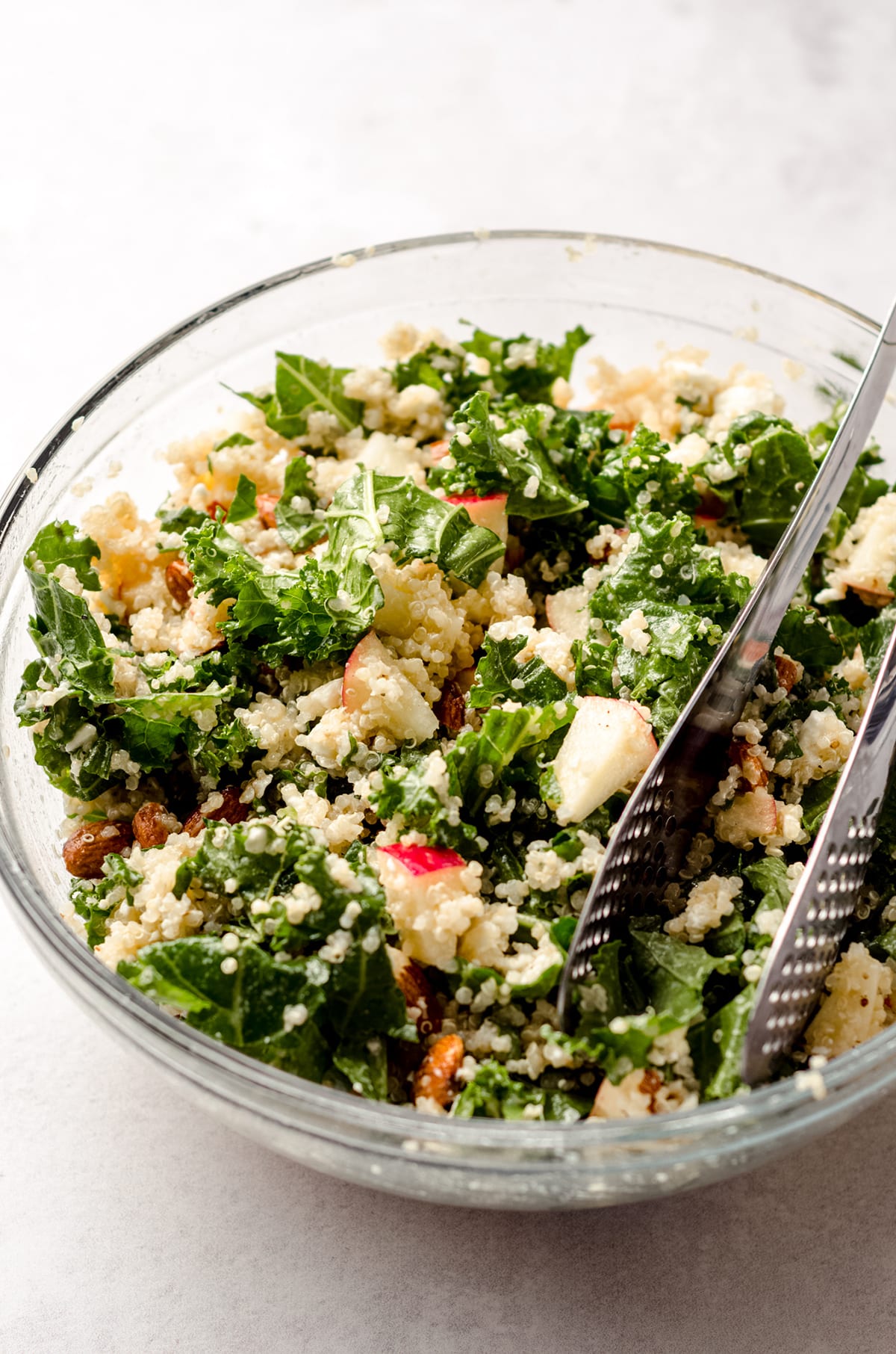 apple, quinoa, and almond kale salad in a bowl