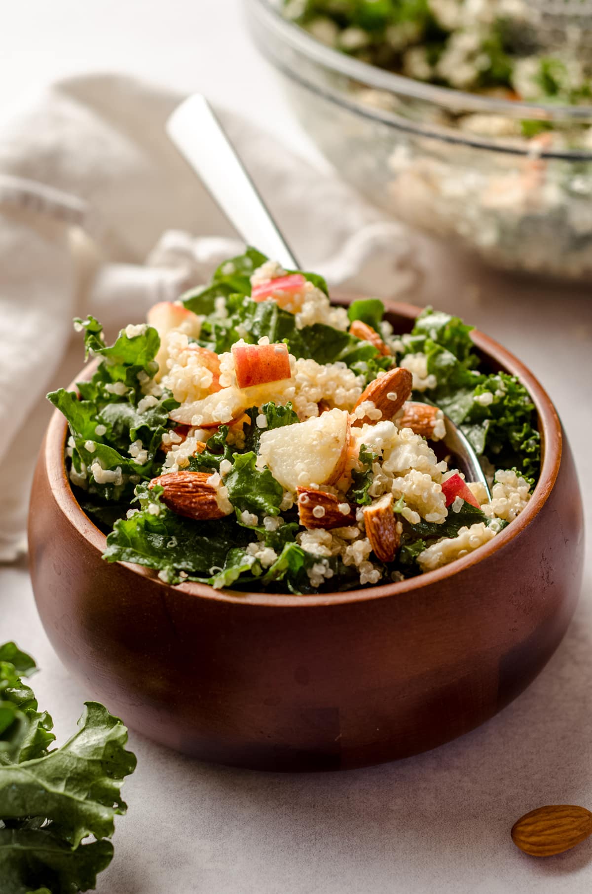 apple, quinoa, and almond kale salad in a bowl