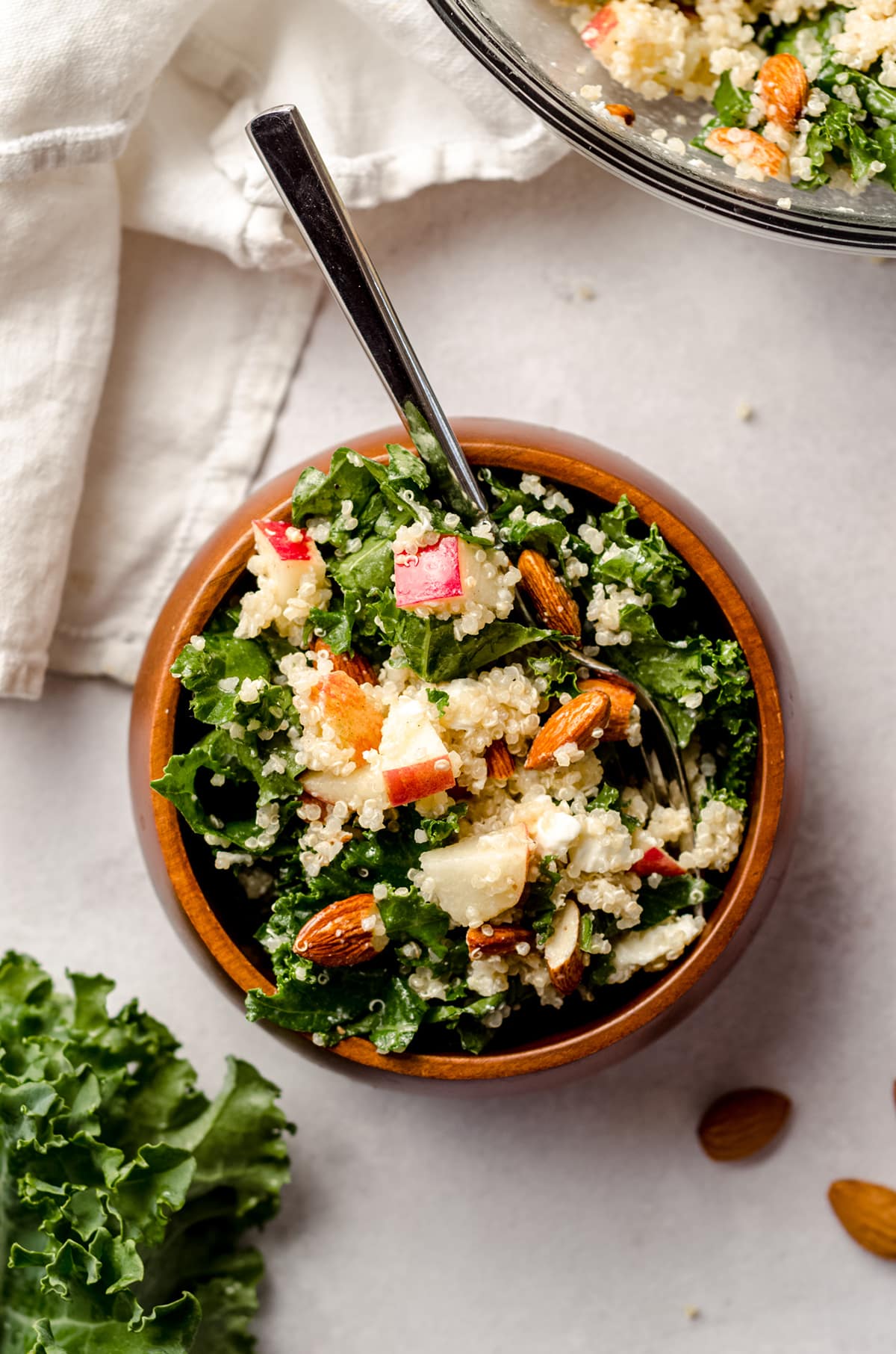 aerial photo of apple, quinoa, and almond kale salad in a bowl