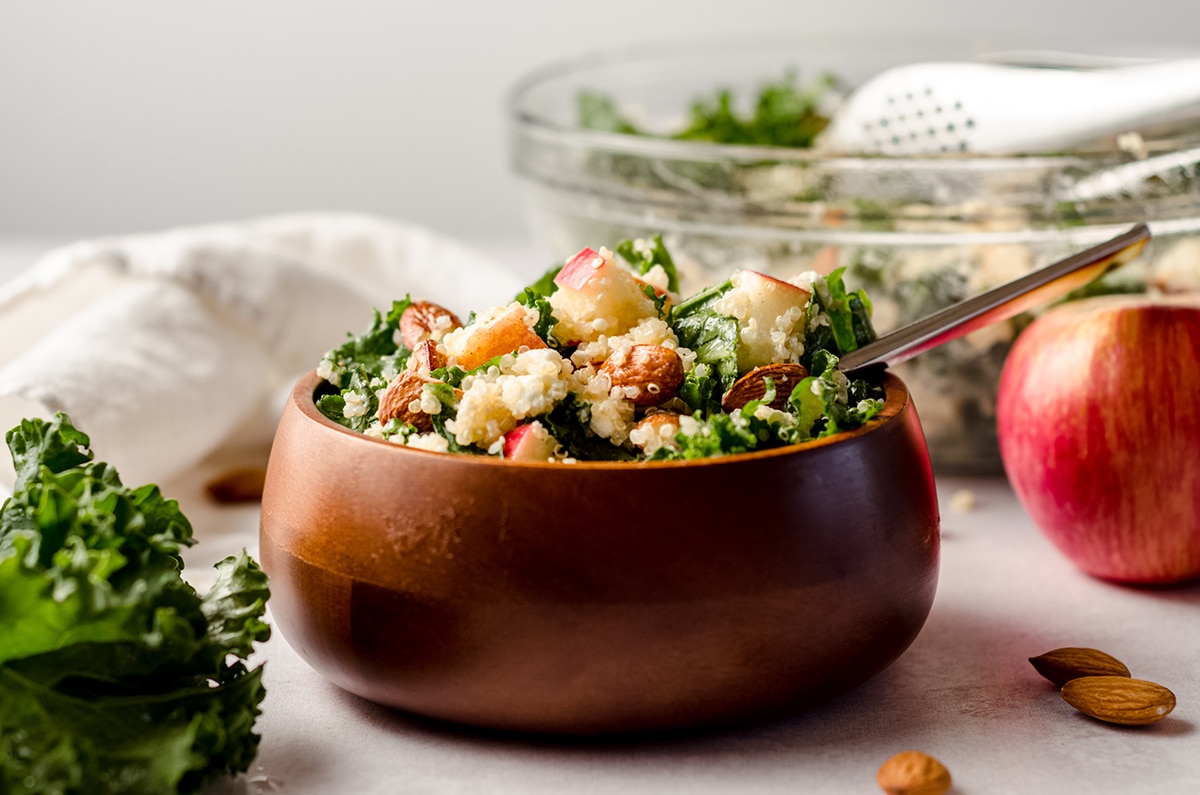 apple, quinoa, and almond kale salad in a bowl