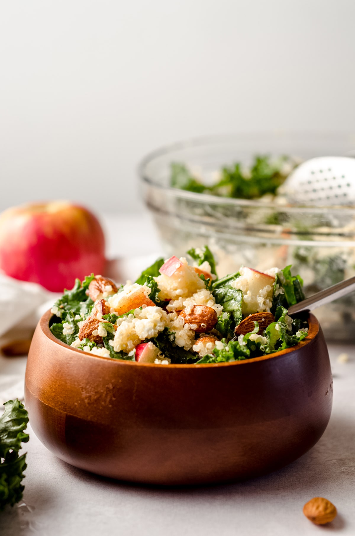 apple, quinoa, and almond kale salad in a bowl