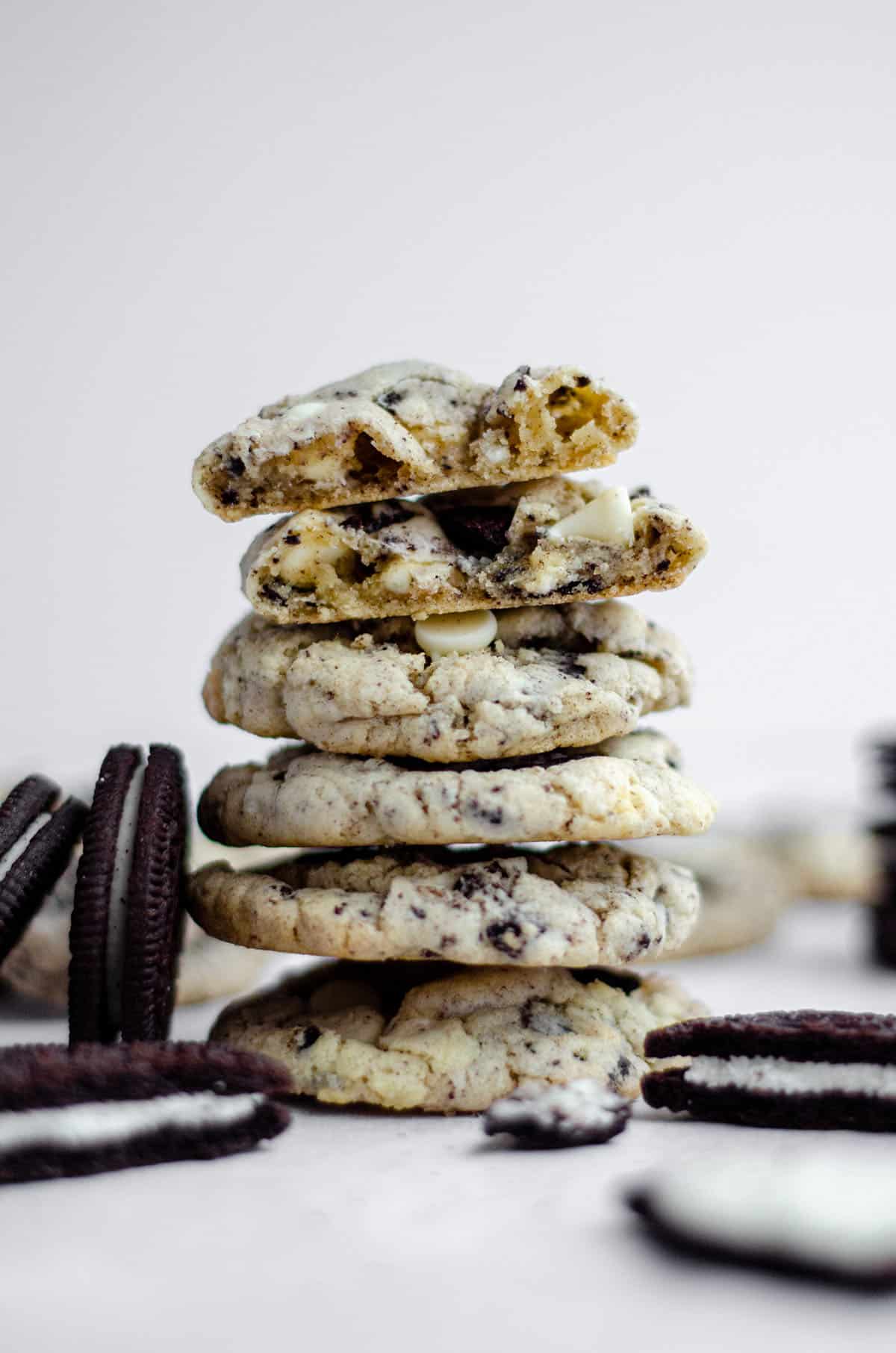 stack of cookies and cream cookies with oreos leaning up against it