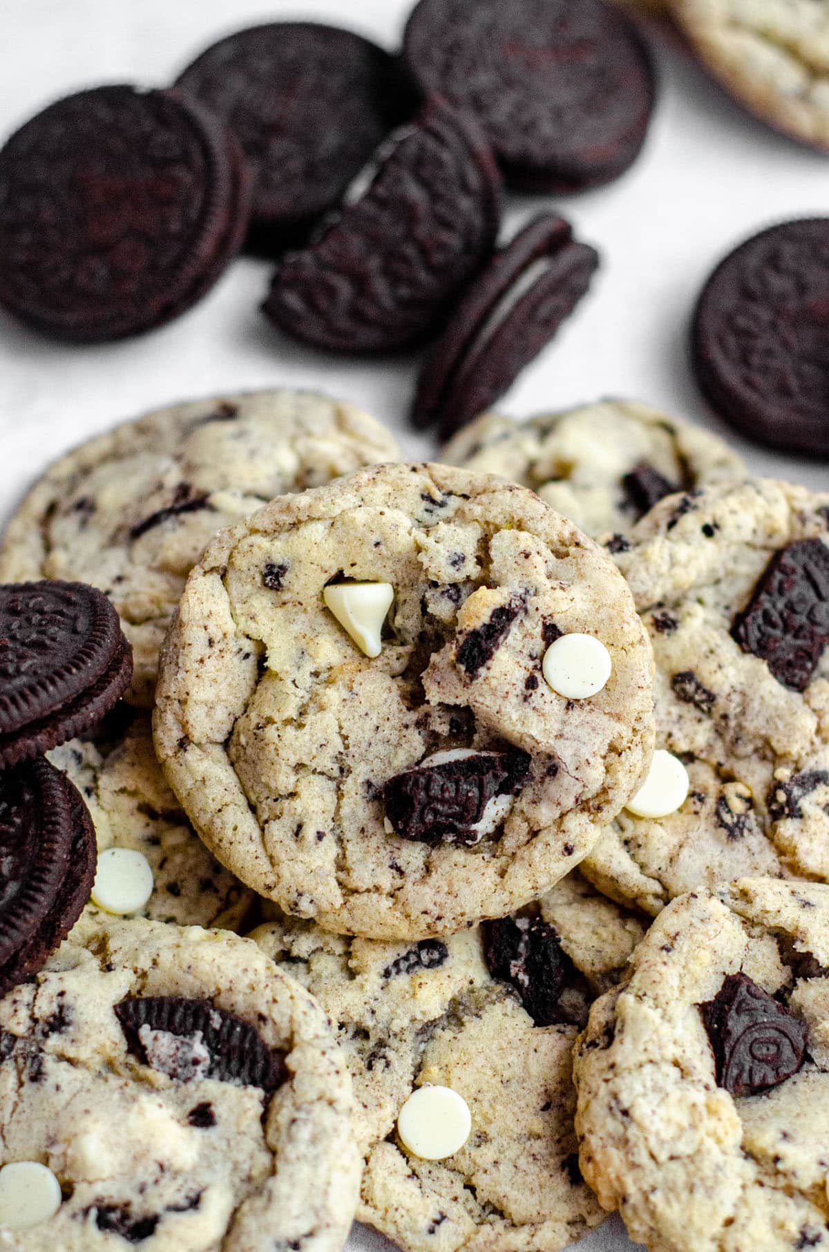 cookies and cream cookies in a pile with lots of oreos surrounding them