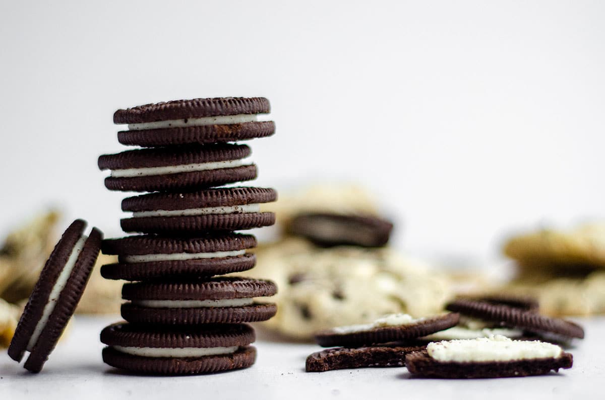 stack of oreos with cookies and cream cookies in the background