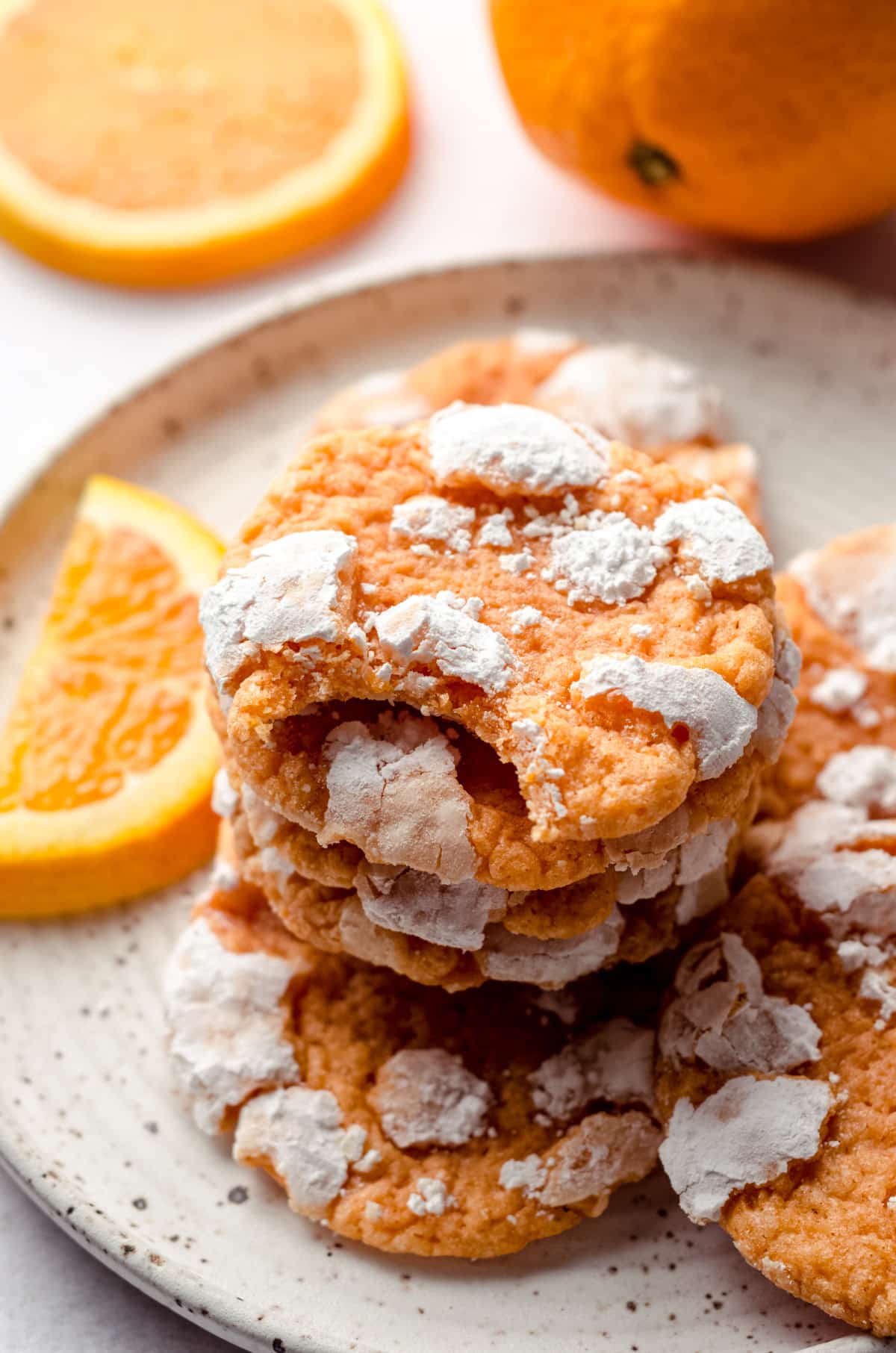 a stack of orange creamsicle cookies with a bite taken out of the one on the top