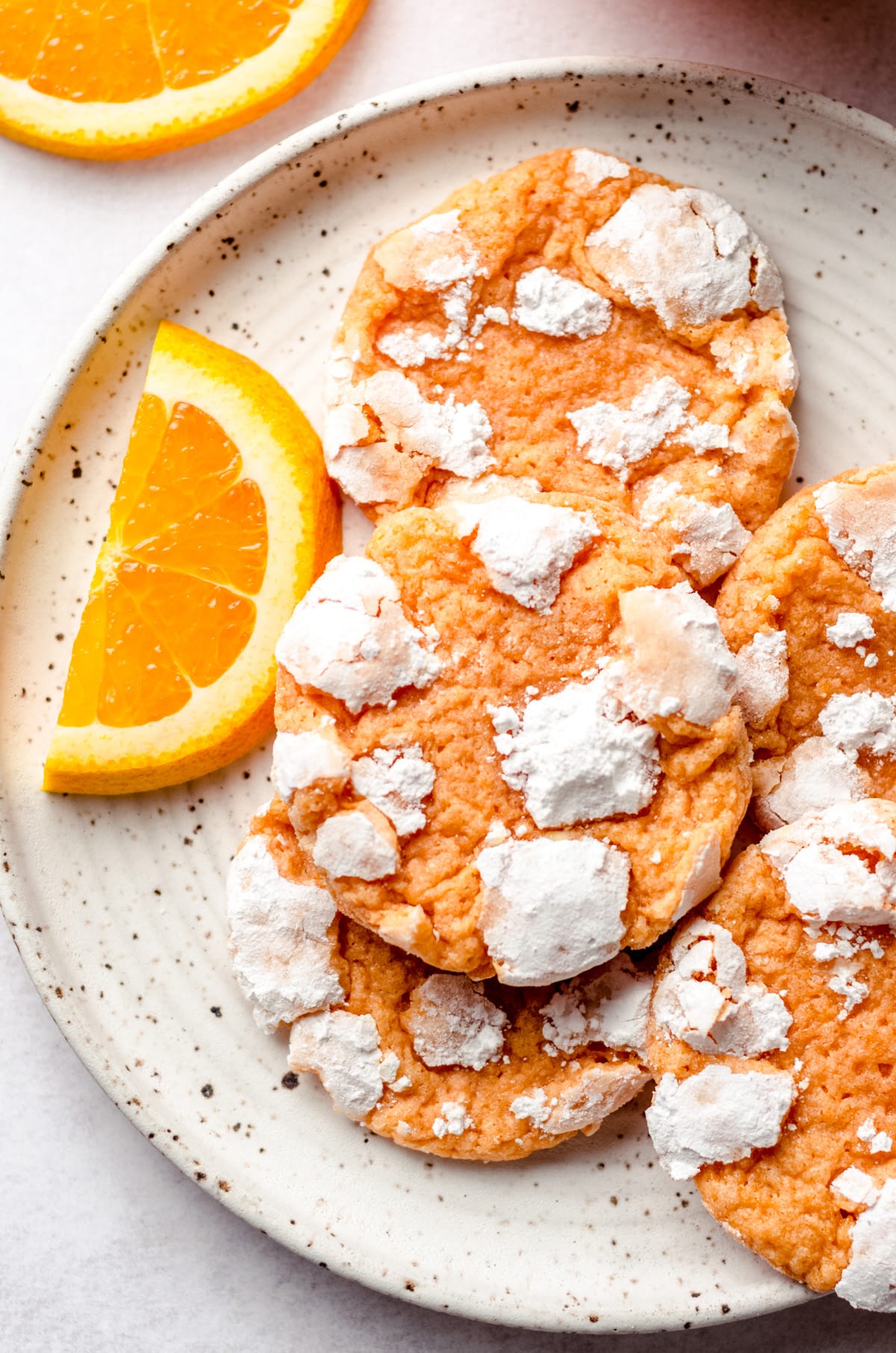 aerial photo of orange creamsicle cookies on a plate with orange slices