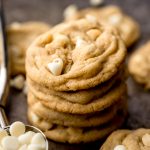 A stack of white chocolate macadamia nut cookies on a baking sheet.