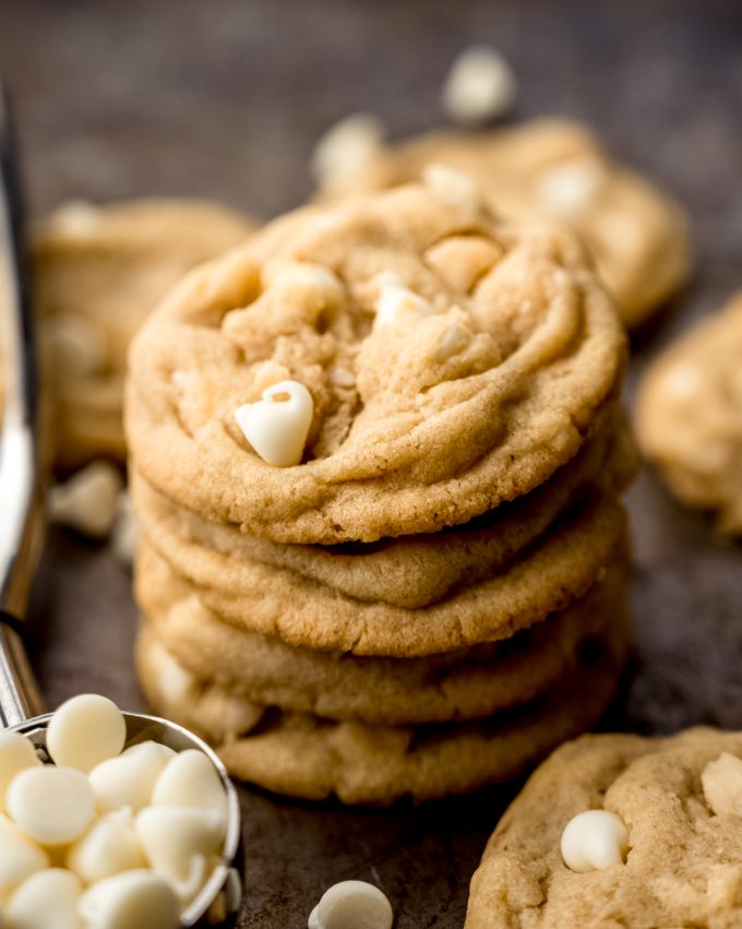 A stack of white chocolate macadamia nut cookies on a baking sheet.
