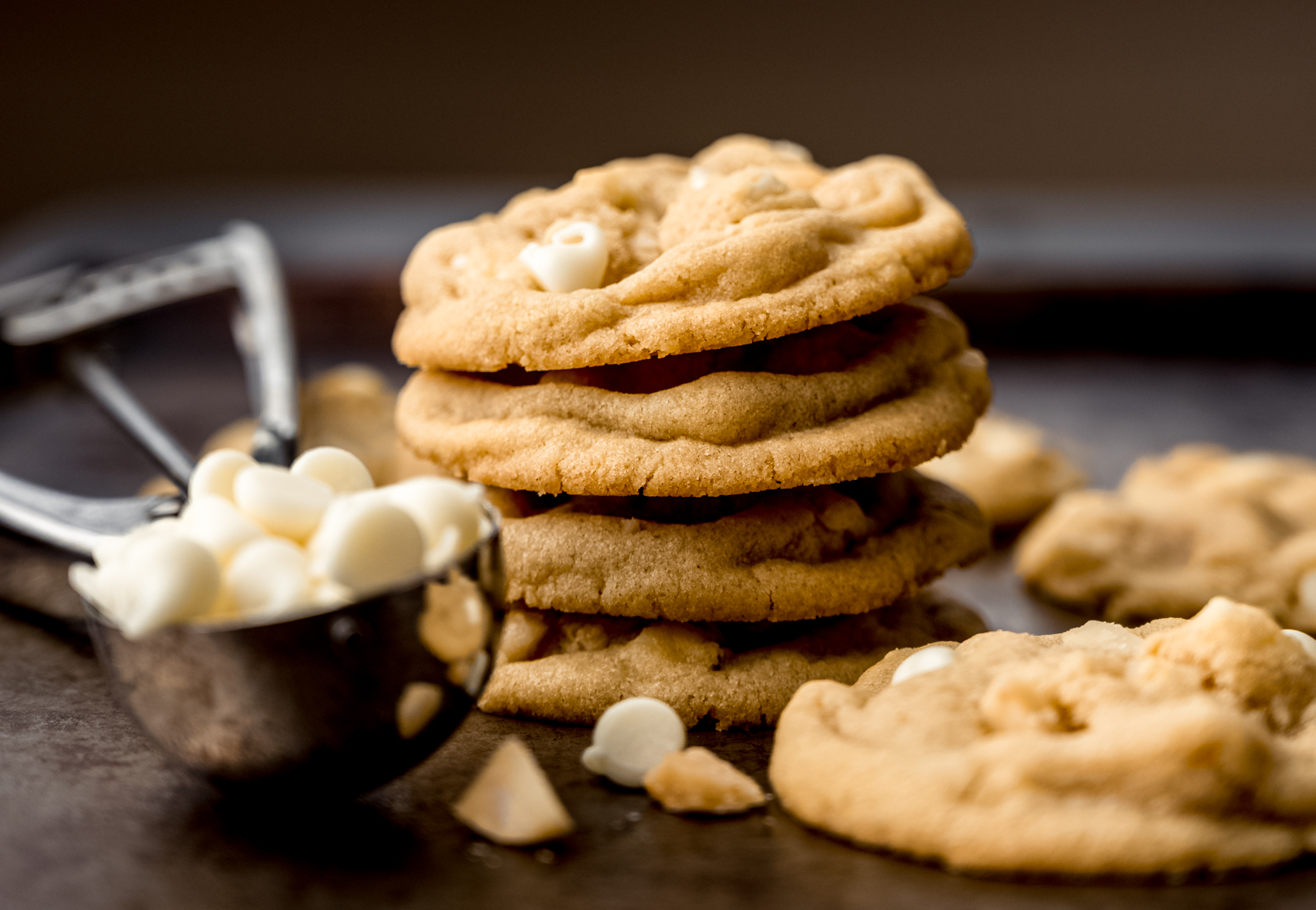 A stack of white chocolate macadamia nut cookies on a baking sheet.