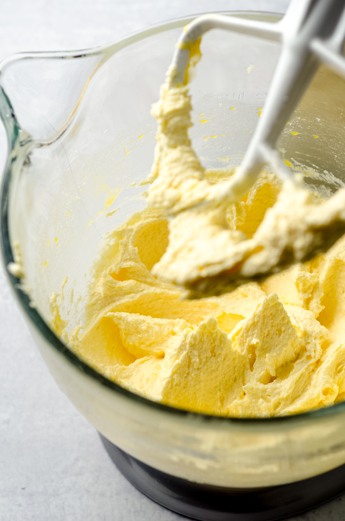 Yellow cake batter in the bowl of a stand mixer.