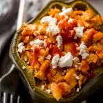 A buffalo chicken stuffed pepper on a plate with a fork.