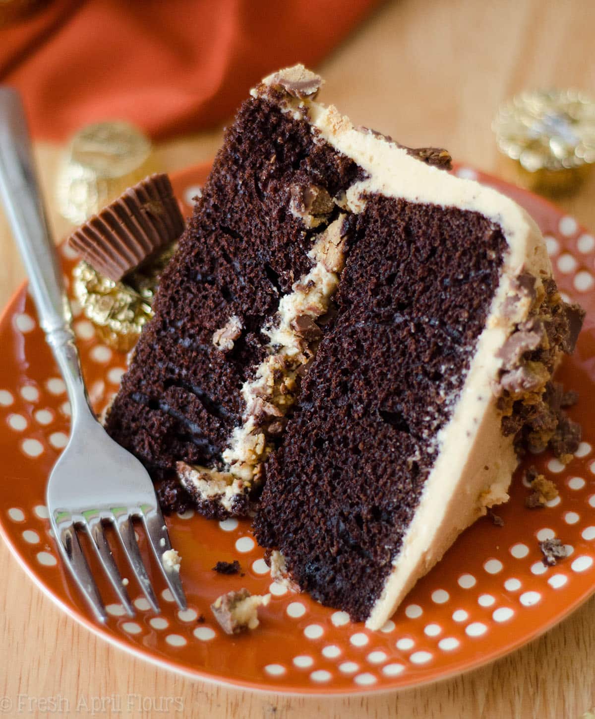 slice of dark chocolate cake with peanut butter frosting on a plate with a fork