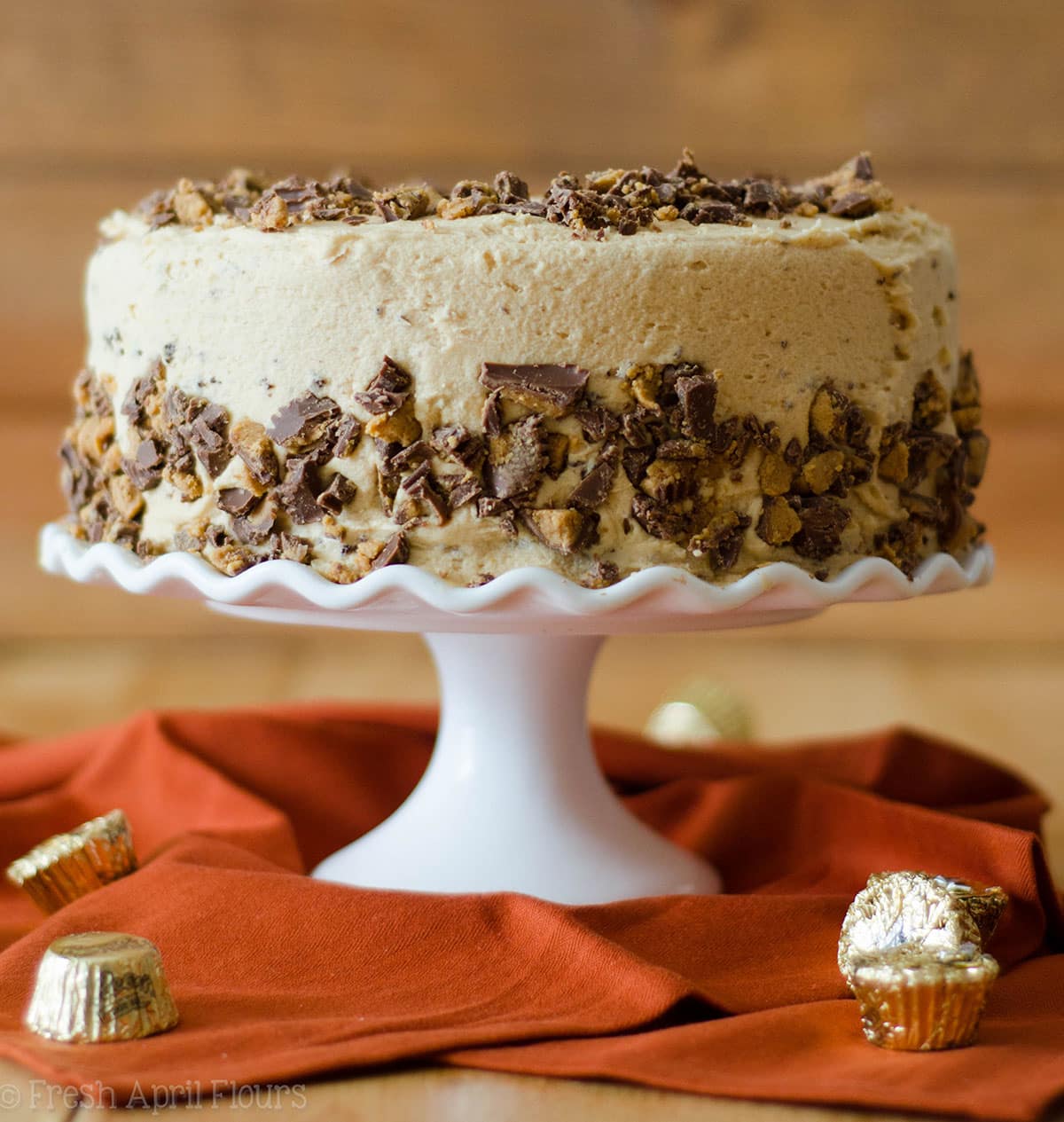 dark chocolate cake with peanut butter frosting on a cake stand