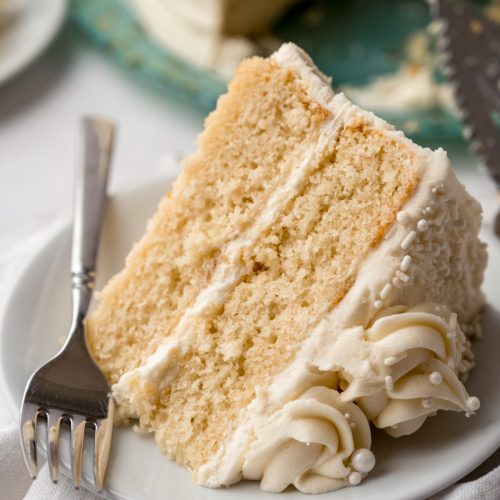 A slice of white cake on a plate with a fork.