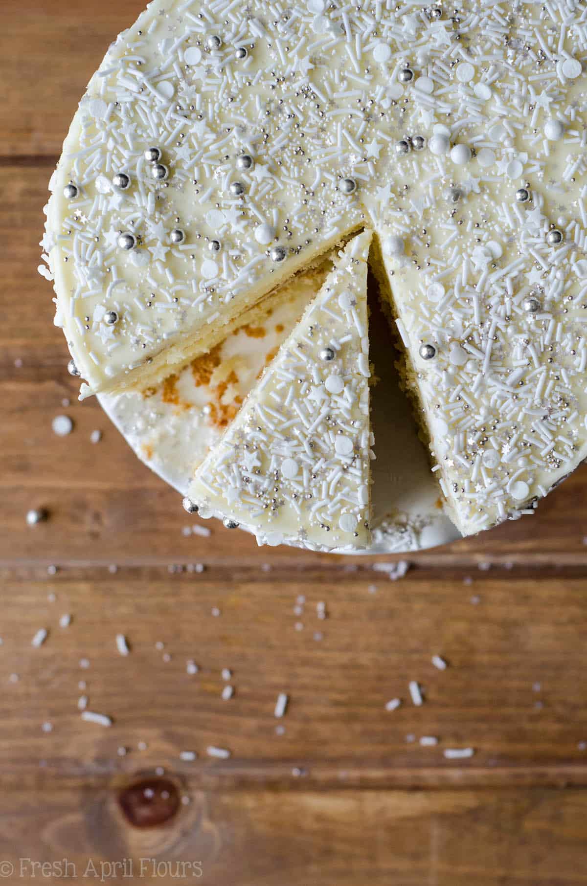 aerial photo of white layer cake sliced with white and silver sprinkles all over it