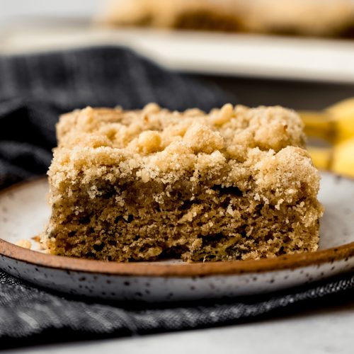 A slice of banana crumb cake on a plate.