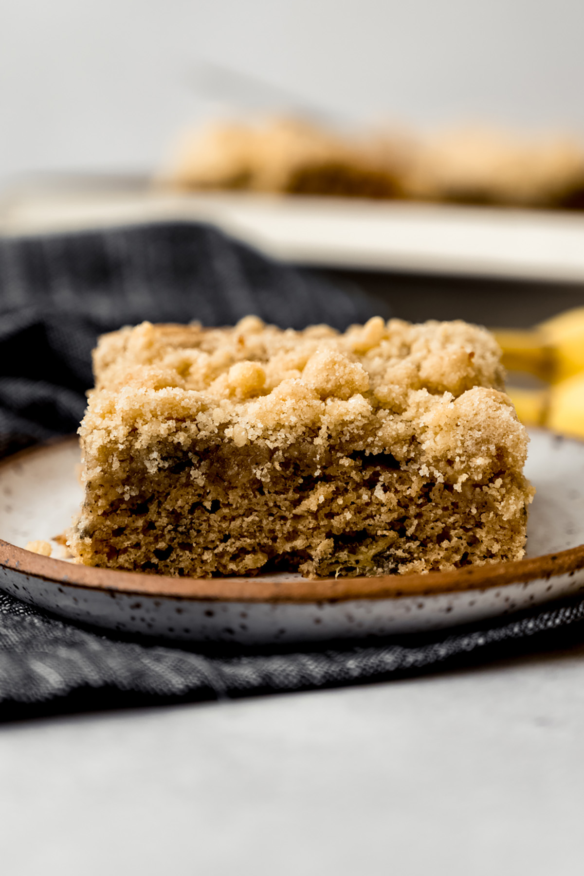 A slice of banana crumb cake on a plate.