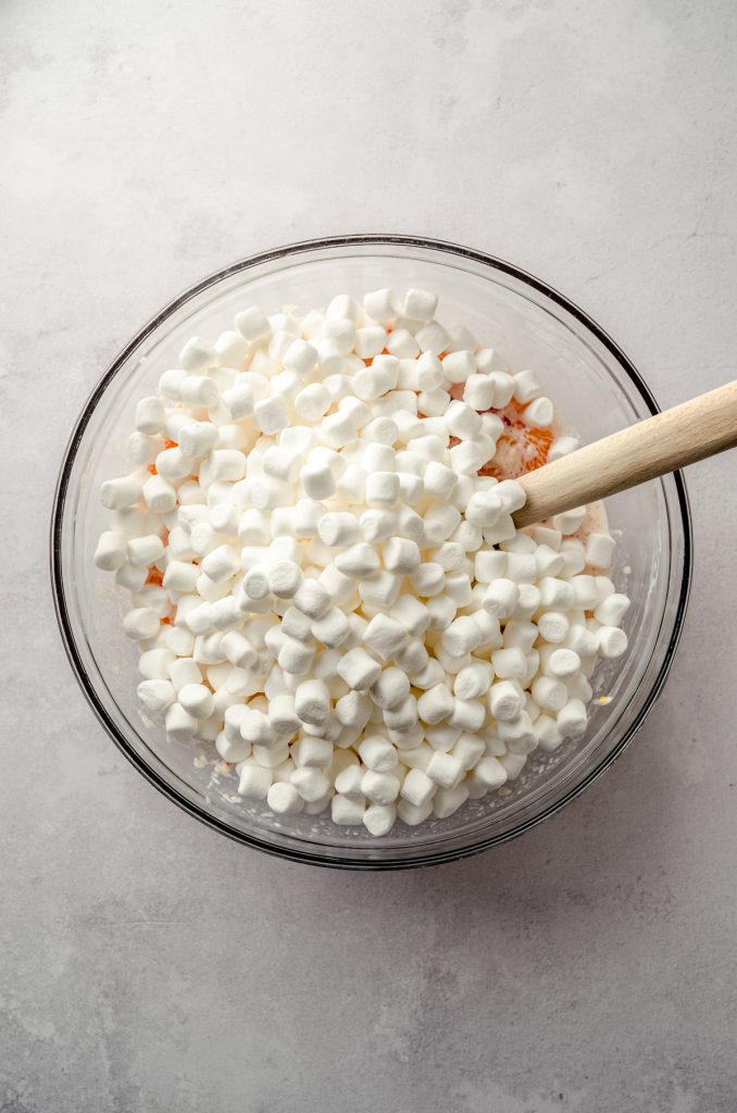 Aerial photo of ingredients for ambrosia salad in a bowl with marshmallows on top ready to be stirred in.