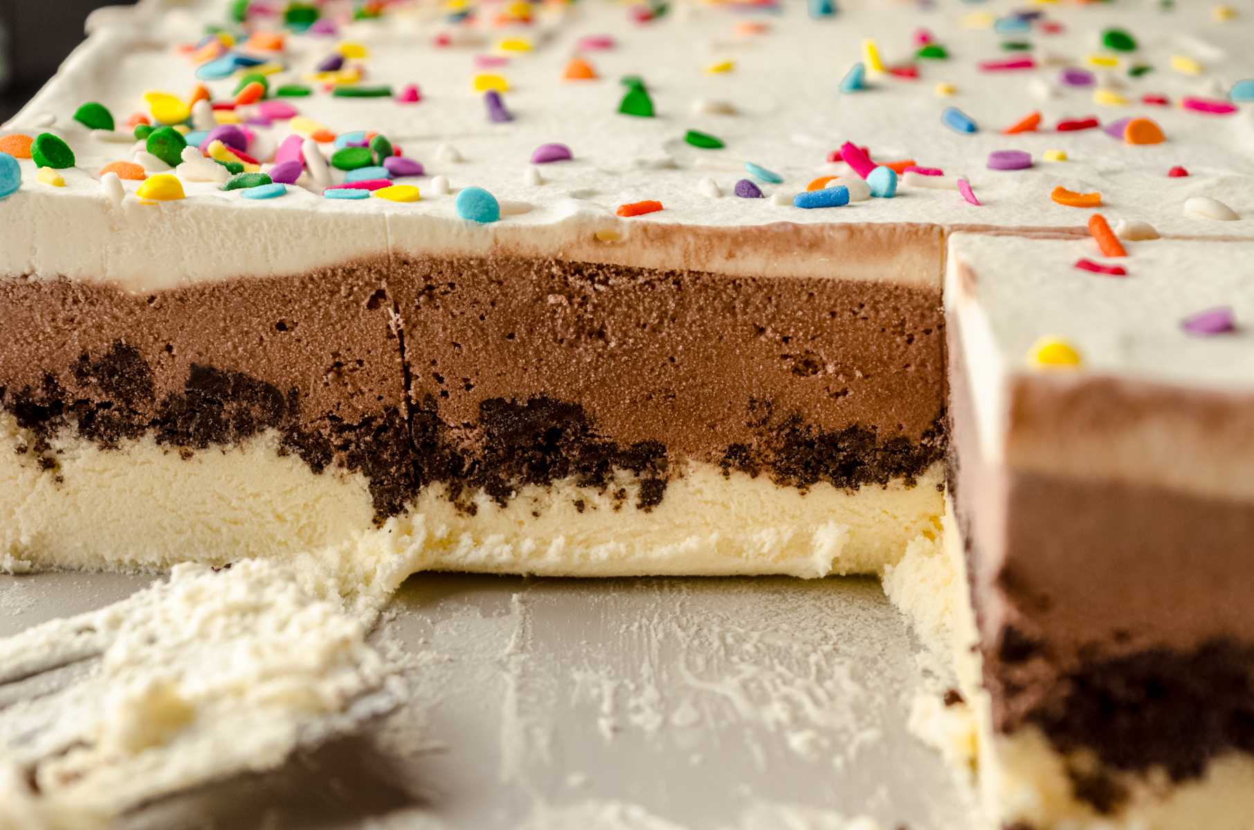 The cross-section of an ice cream sheet cake in a baking dish.