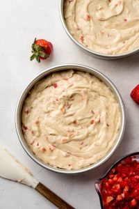 Aerial photo of strawberry cake batter in cake pans.