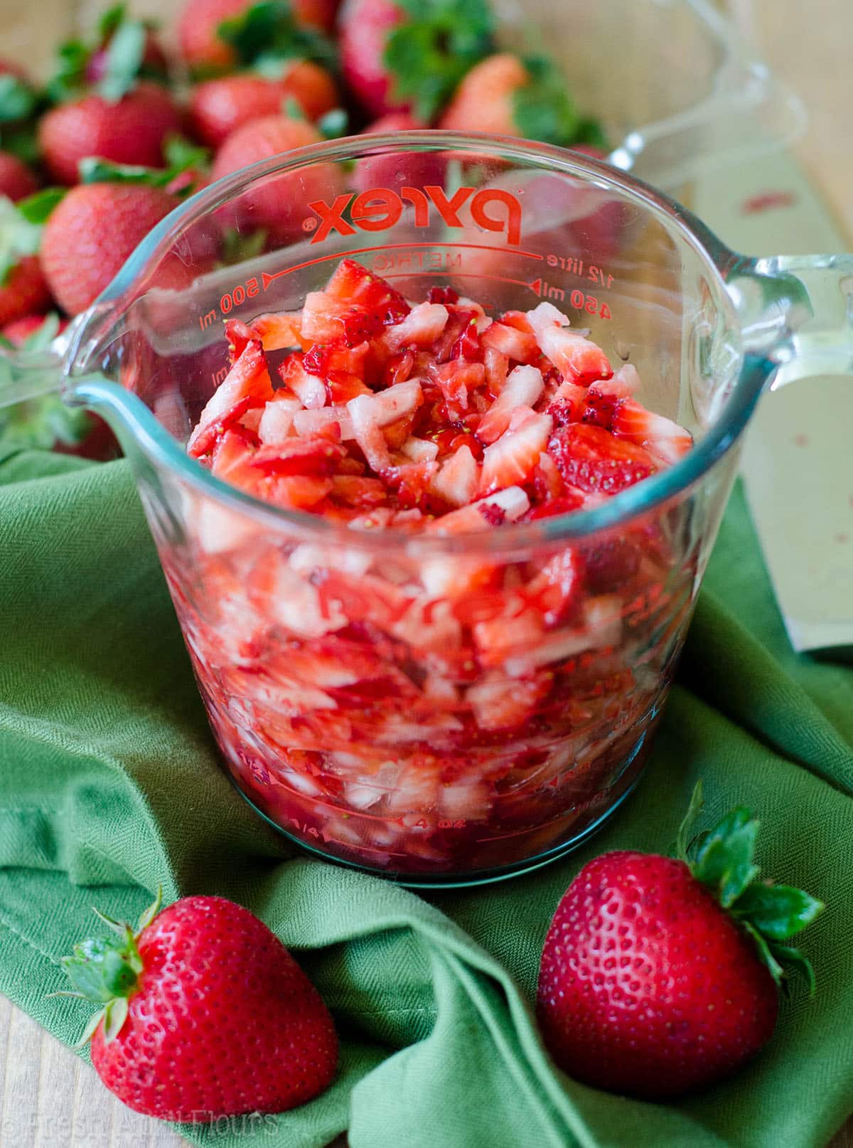 cut strawberries in a glass measuring cup