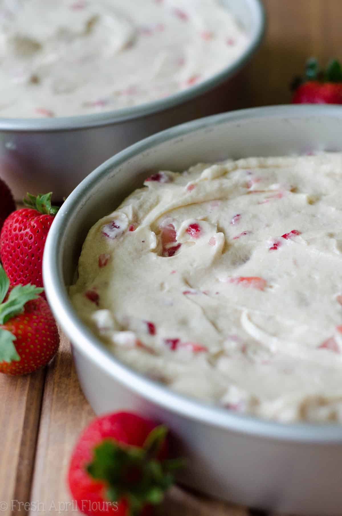 fresh strawberry cake batter in cake pans ready to bake