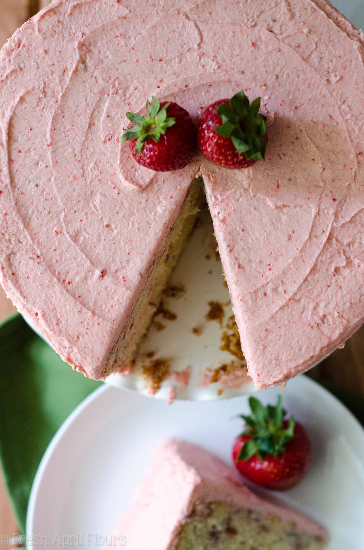 aerial photo of fresh strawberry cake with a slice cut out of it
