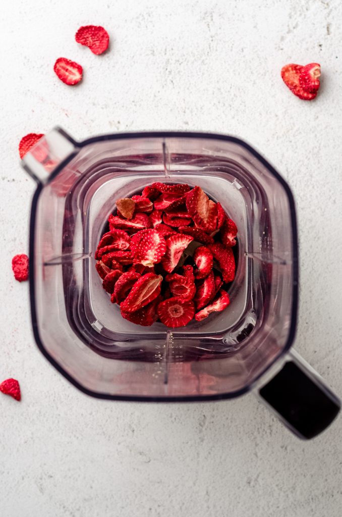 Aerial photo of blender full of freeze-dried strawberries.