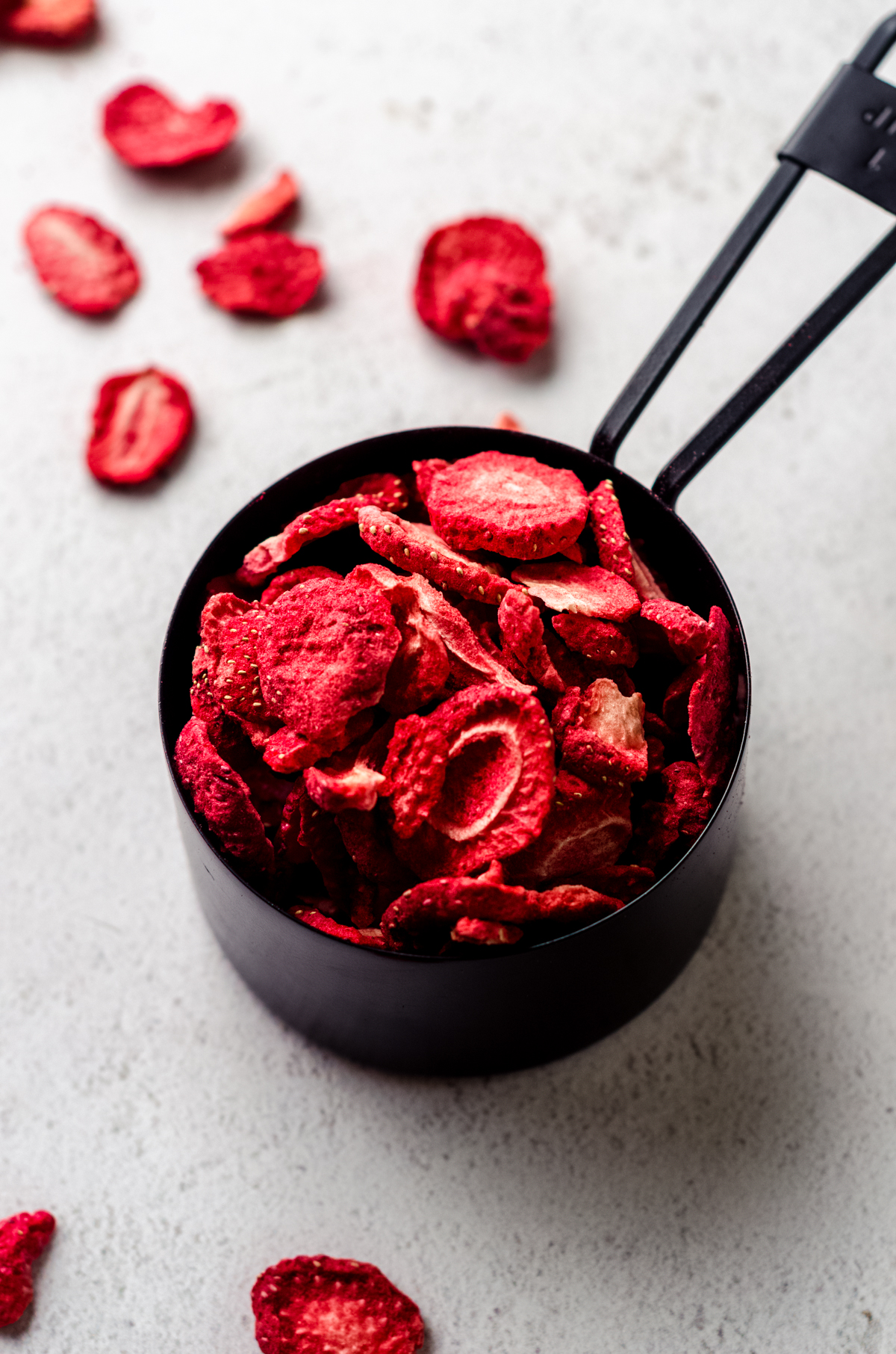 Measuring cup with freeze-dried strawberries in it.