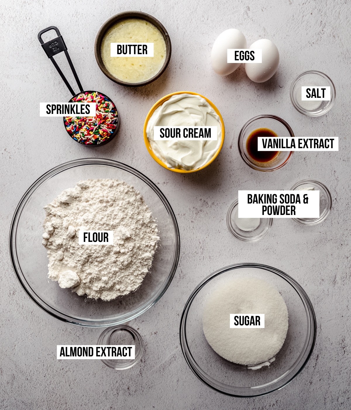 Aerial photo of ingredients for funfetti quick bread with text overlay labeling each ingredient.