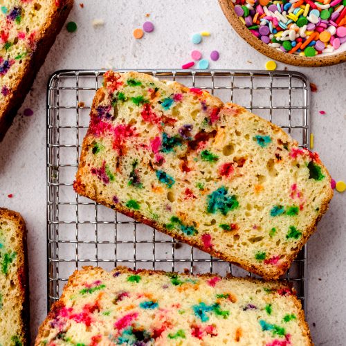 Aerial photo of slices of funfetti bread on a wire cooling rack.