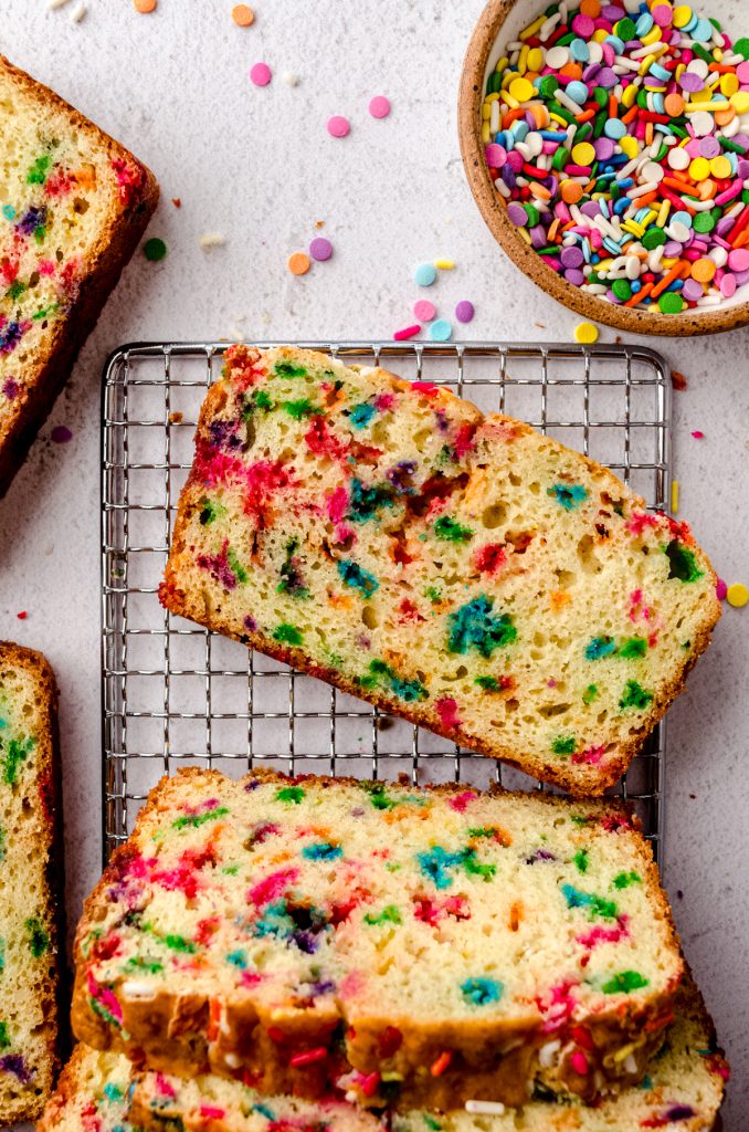 Aerial photo of slices of funfetti bread on a wire cooling rack.