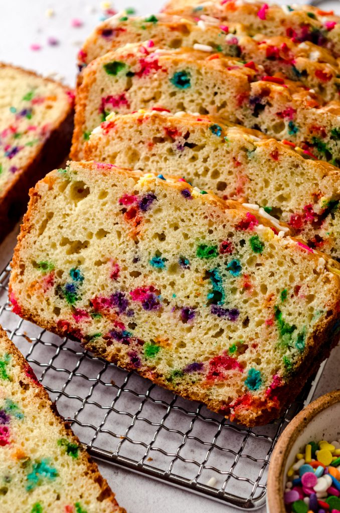 Slices of funfetti bread on a wire cooling rack.