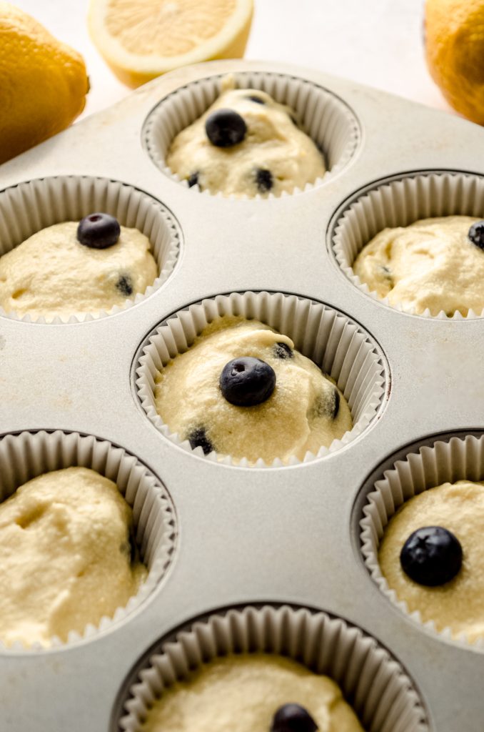 Lemon blueberry cupcake batter portioned into wells of a cupcake pan.