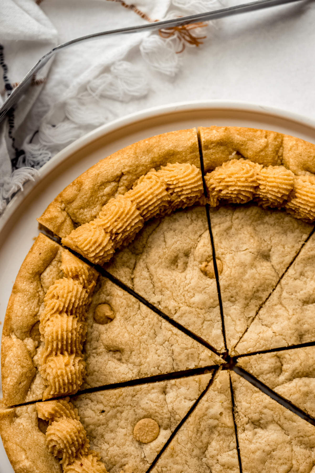 Aerial photo of a peanut butter cookie cake that has been cut into slices.