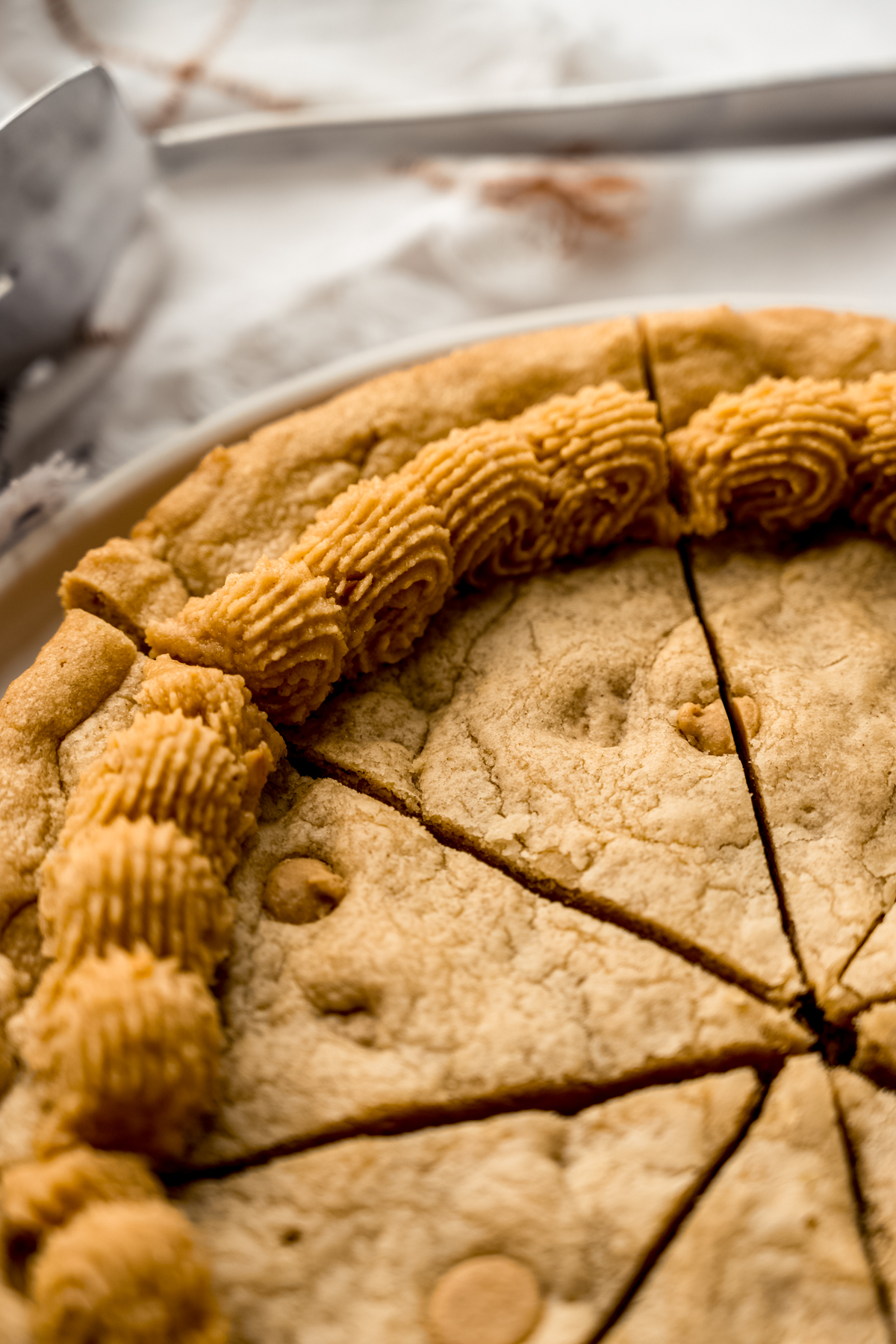 A peanut butter cookie cake that has been cut into slices.