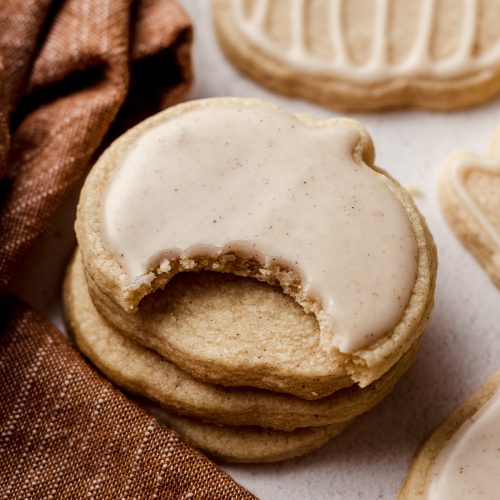 pumpkin shaped pumpkin sugar cookie with a bite taken out of it