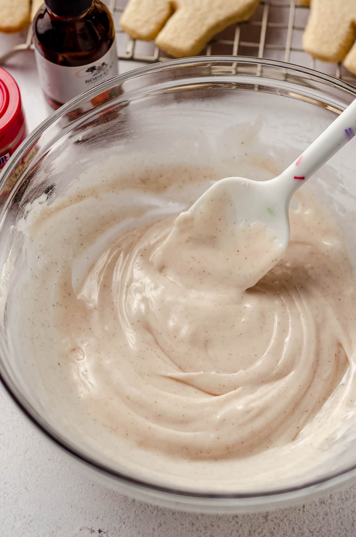 pumpkin spice royal icing in a bowl with a spatula