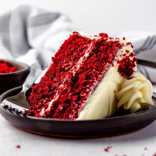 A slice of red velvet cake on a plate with a fork.