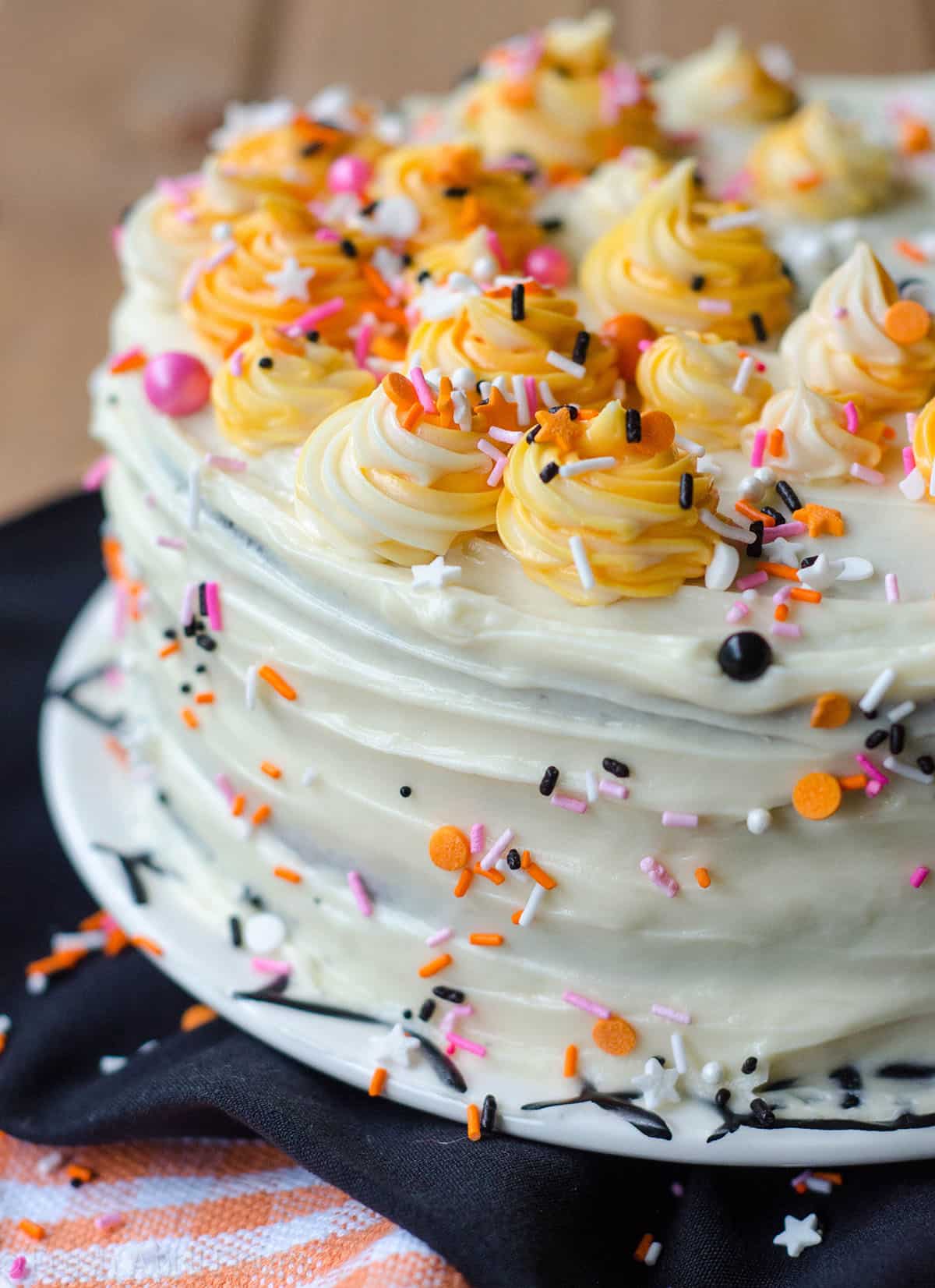 black velvet layer cake decorated with pink and orange sprinkles